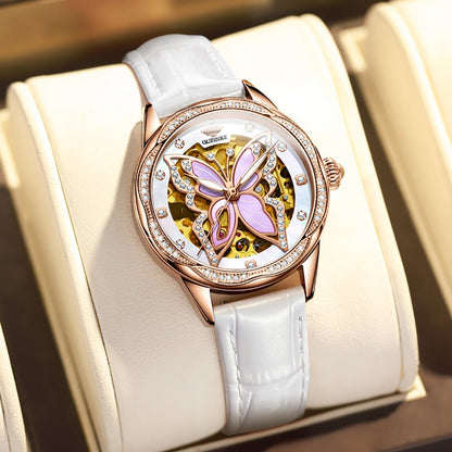 Luxury watch with butterfly design on a white strap in a box