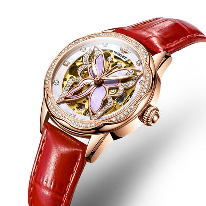 Luxury watch with red strap and intricate design on a white background