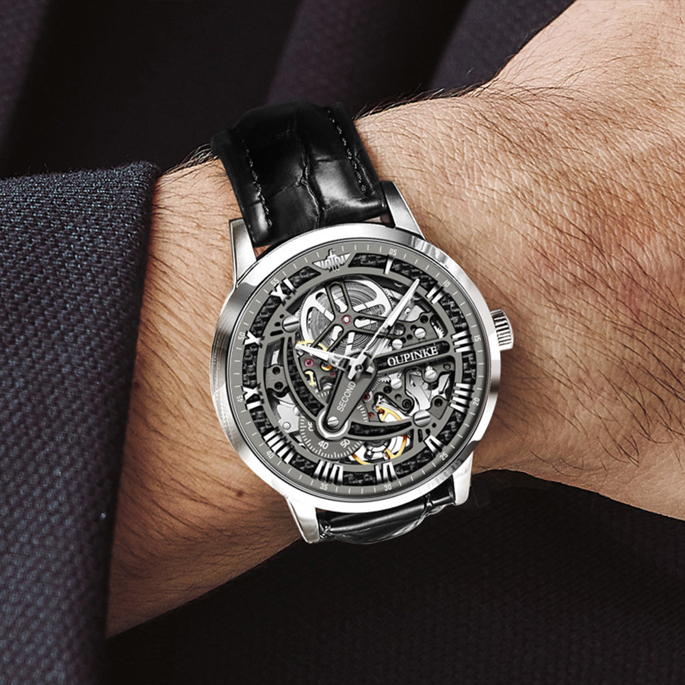 OUPINKE 3173 silver case black skeleton watch worn on wrist with black leather strap